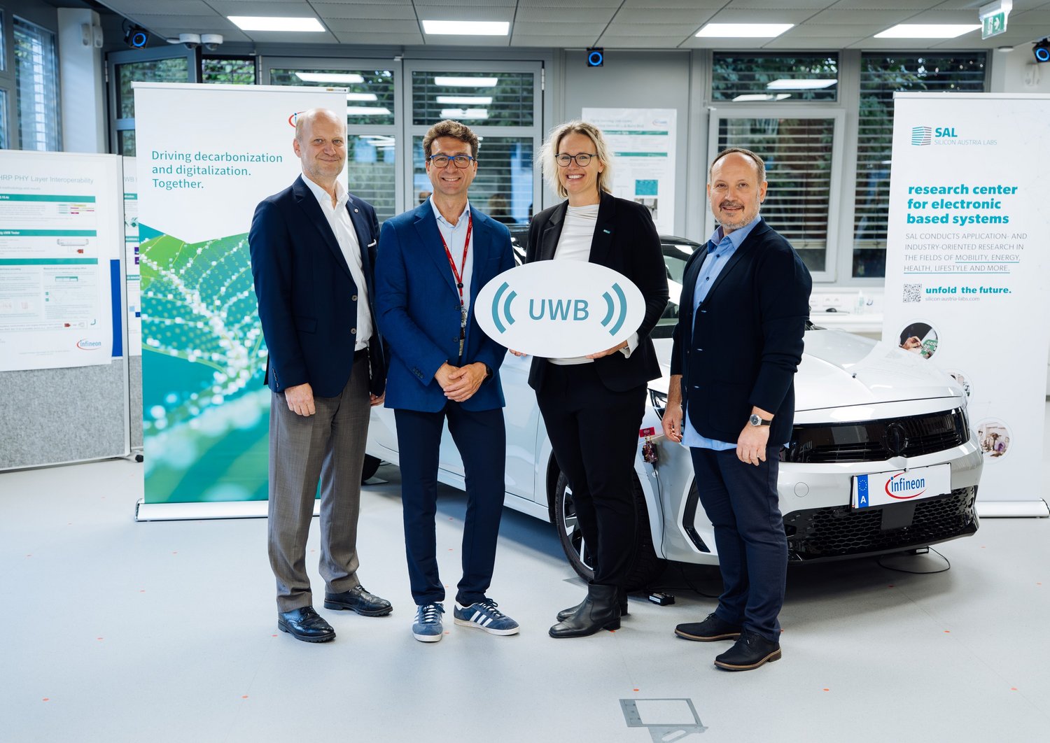 Vier Personen im UWB Lab mit einem Schild in der Hand