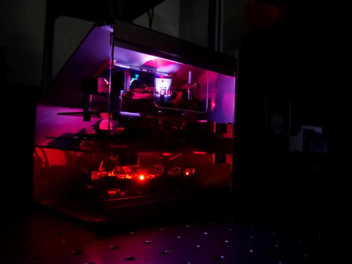 MEMS Mikrospiegel Labordemonstrator. Das Gerät leuchtet in Rot-Lila Farben
