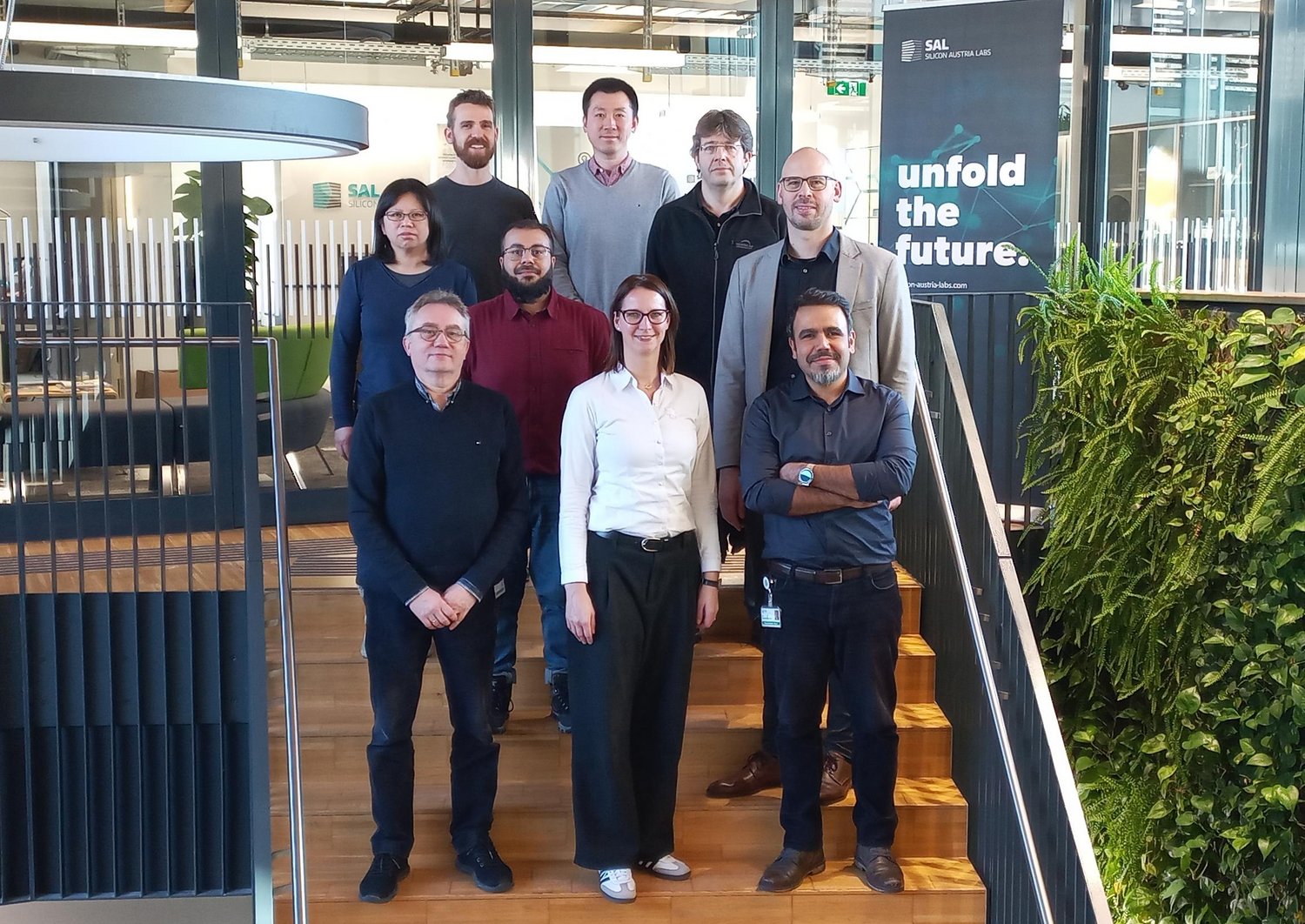 Gruppenfoto des Projektteams von SURFBOND mit 9 Personen auf den Stiegen im SAL-Gebäude in Villach