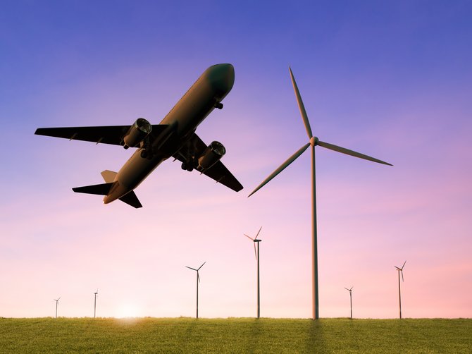 Grüne Wiese, Windräder, Flugzeug hebt gerade ab