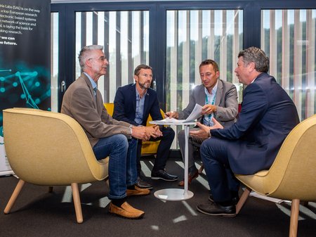 Four men sitting at a table and have a meeting