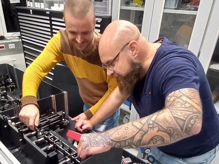 Matteo in the office in front of a test set-up with a colleague