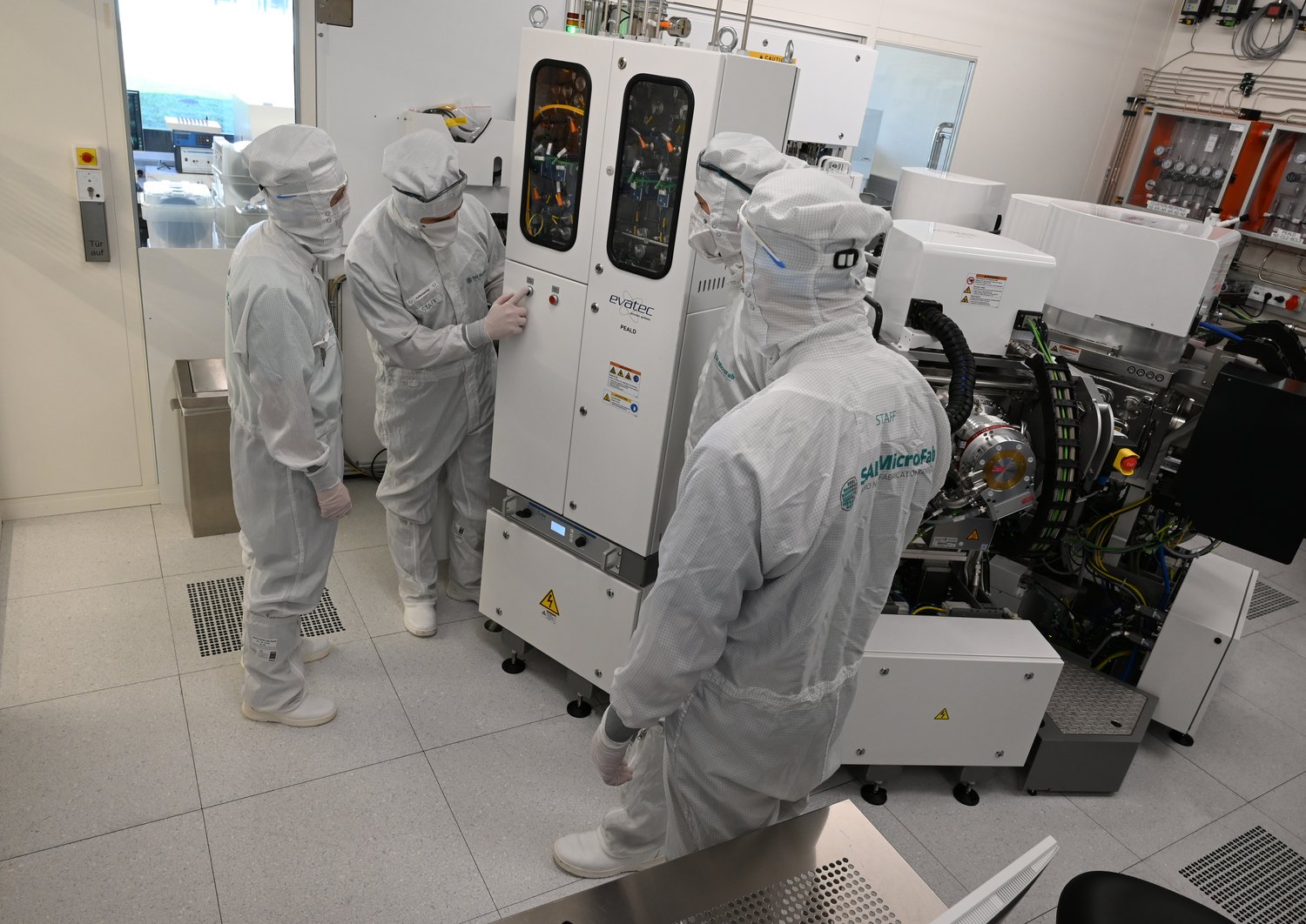 Researchers in front of the Evatec Clustertool in the Cleanroom