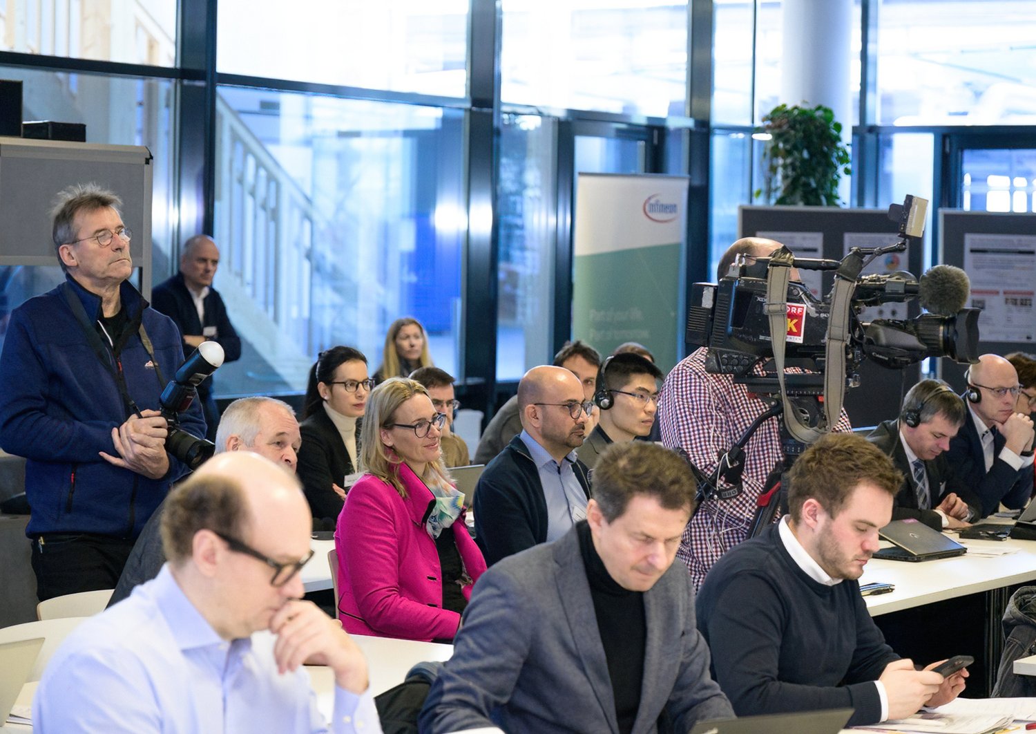 Participants listen to the press conference in a large room