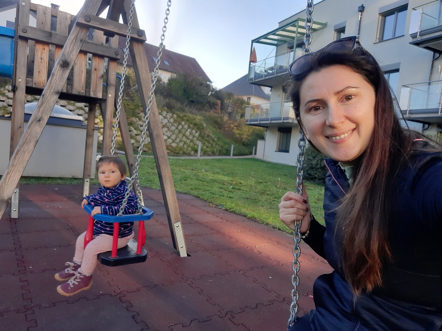 Fjolla and her daughter on a swing in front of their home