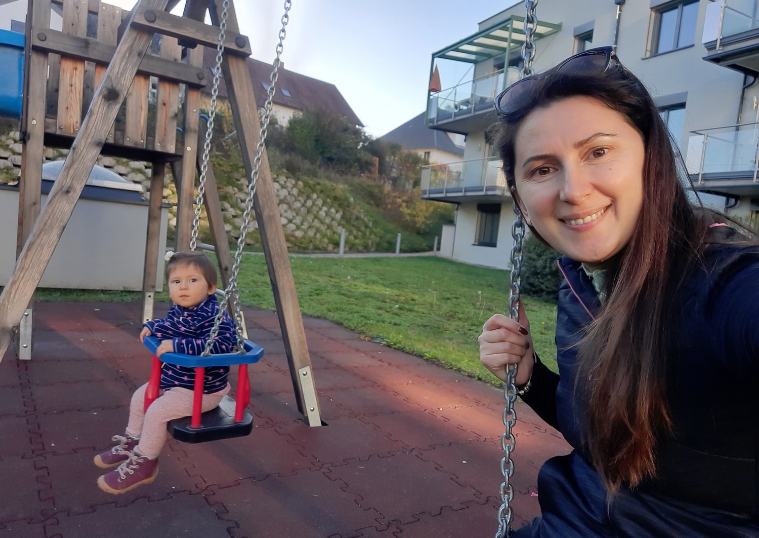 Fjolla and her daughter on a set of swings