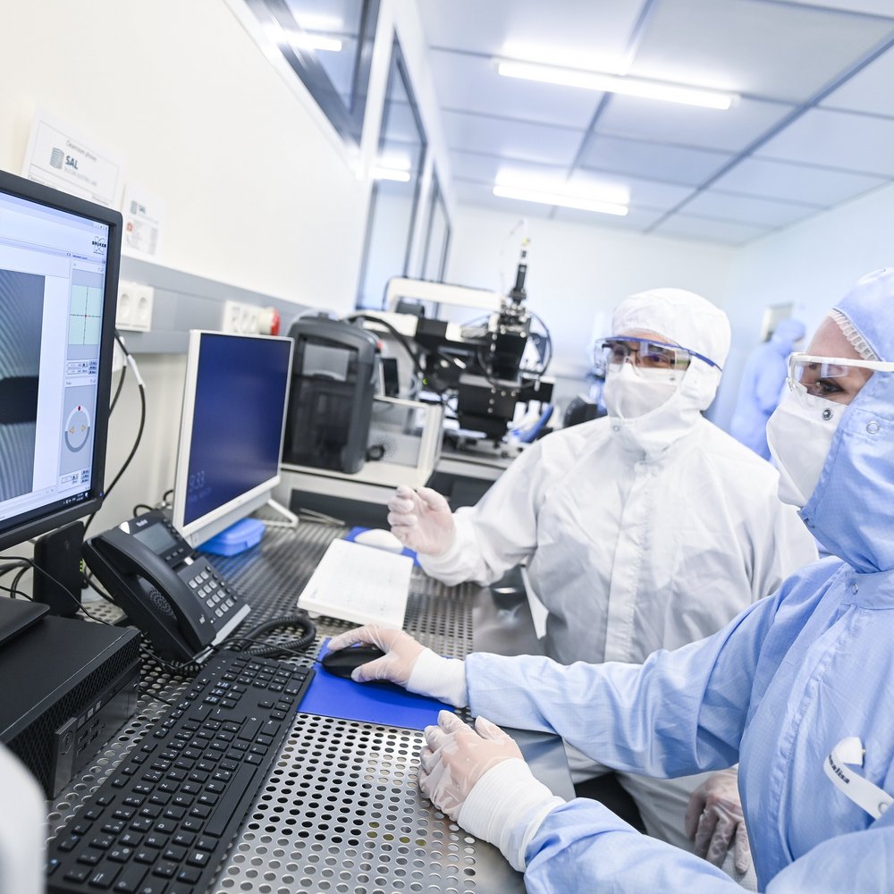 two researchers in protective clothing in the cleanroom