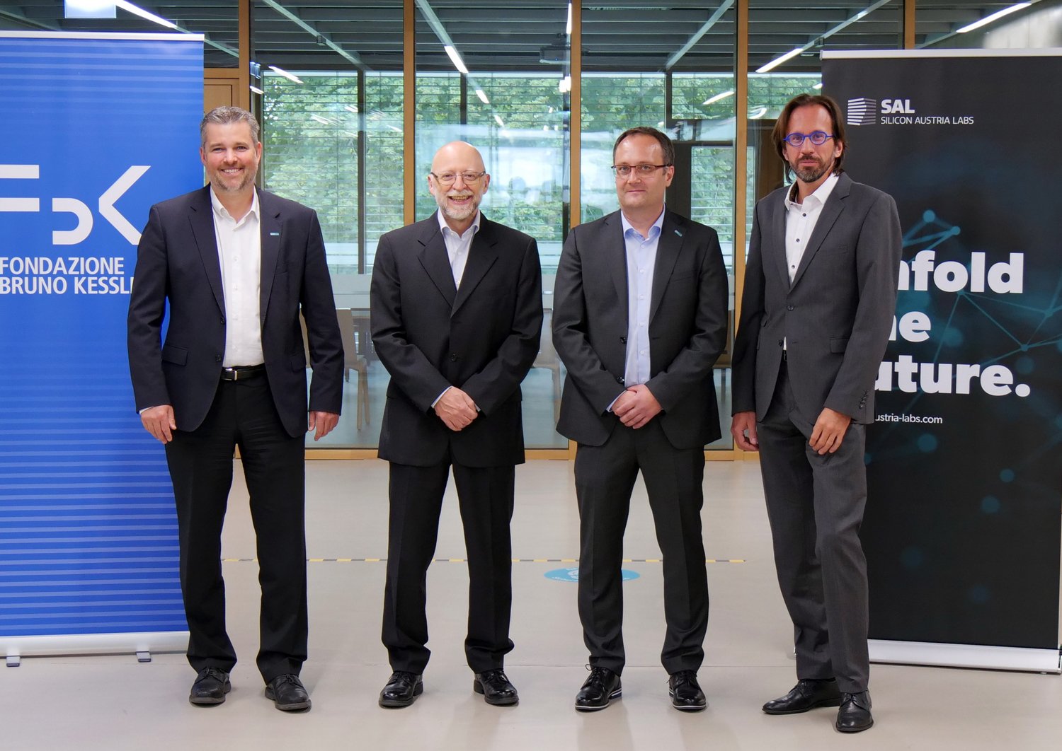 Gerald Murauer, Alessandro Cimatti, Ingo Pill and Andras Montvay stand next to each other and smile into the camera