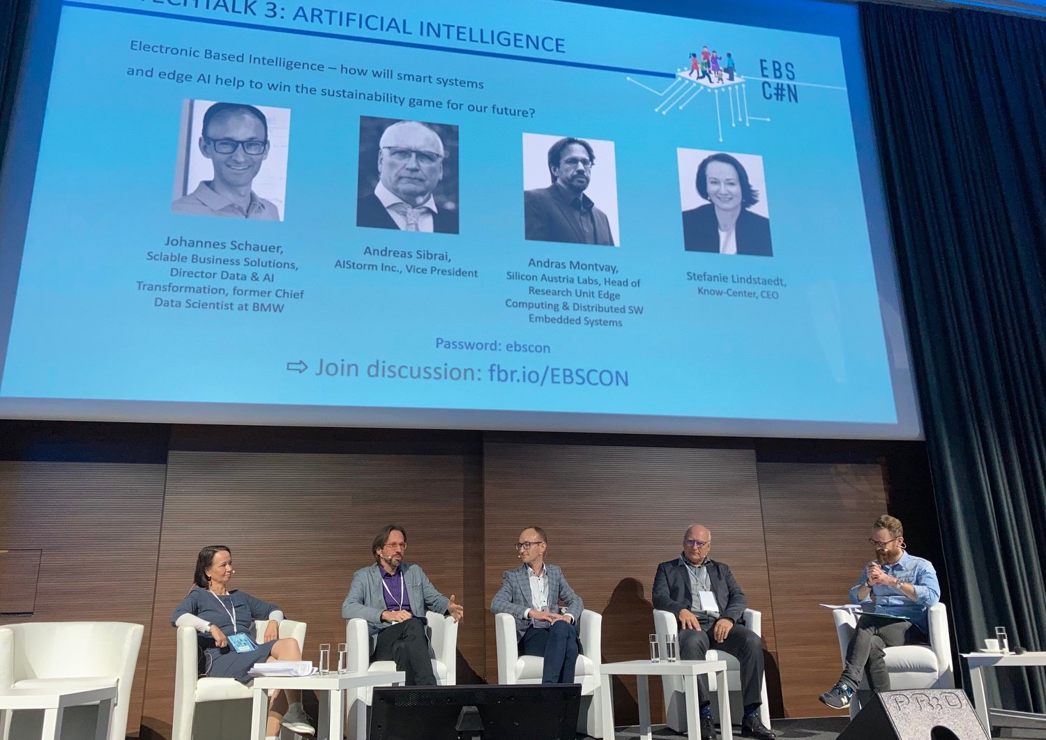 Experten und Expertinnen sprechen am Podium, im Hintergrund an der Wand ist der Text "Techtalks 3: Artificial Intelligence" zu lesen