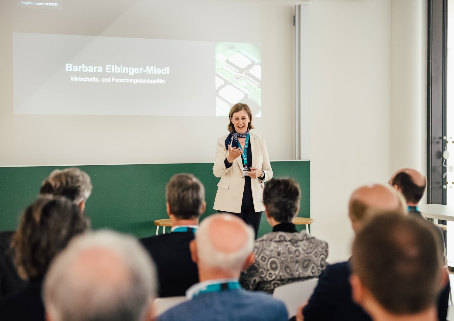 Barbara Eibinger-Miedl hält eine Präsentation vor einer Gruppe an Menschen