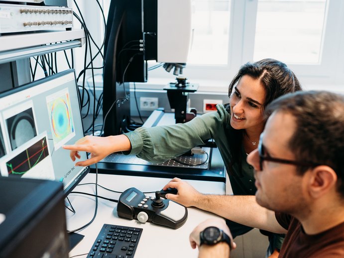 Forscherinnen auf einem Messaufbau im Labor