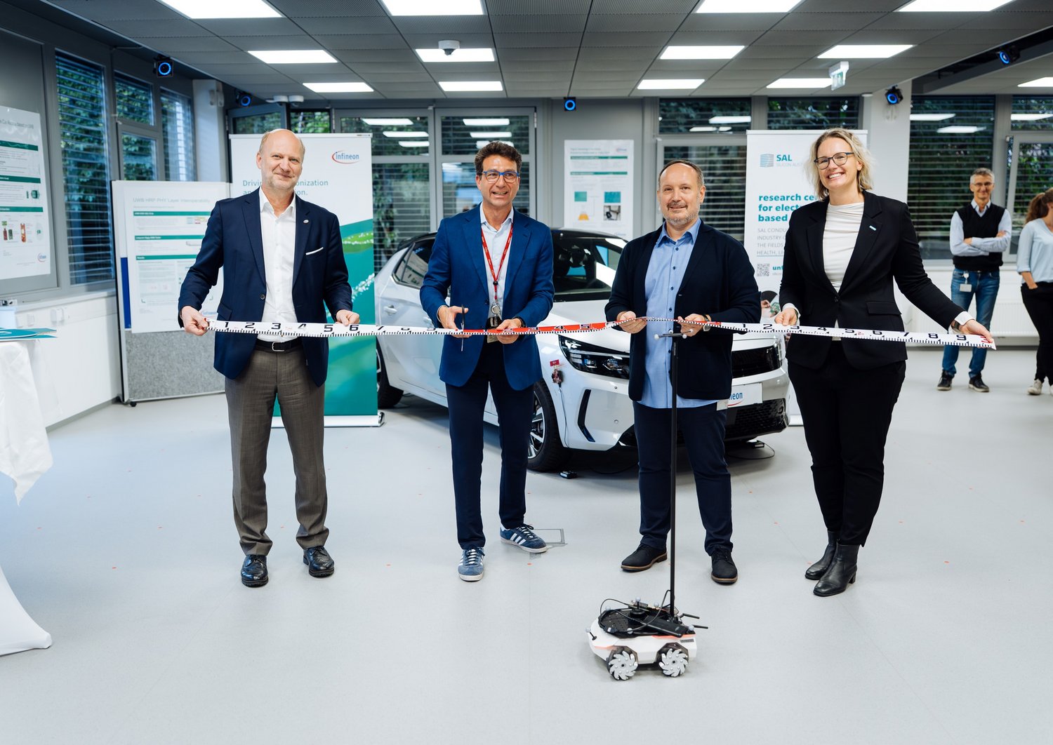 Vier Personen im UWB Lab beim Durchschneiden des Eröffnungsbandes