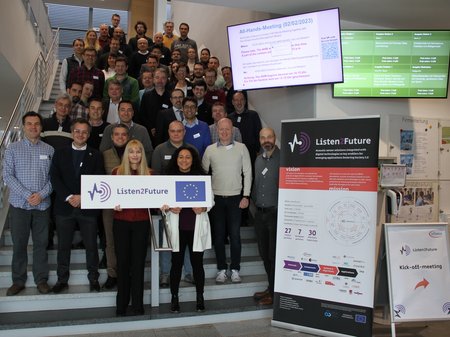 Project team posing on stairs with a Listen2Future sign