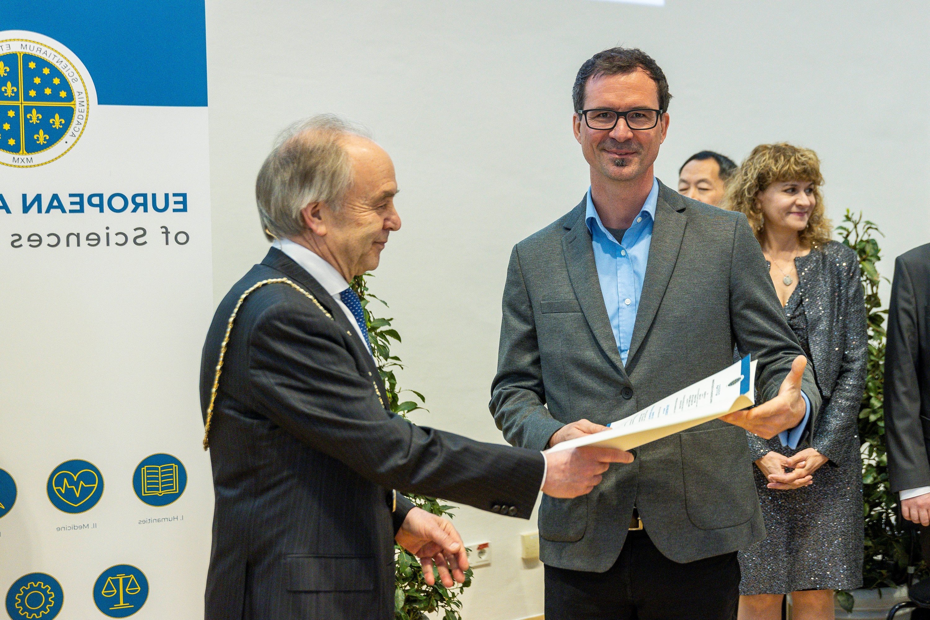 Jürgen Kosel receiving his membership certificate for the European Academy of Science by an elder member