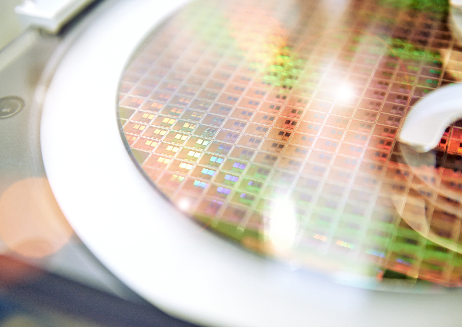 A close up of a wafer which is glowing in rainbow colors 