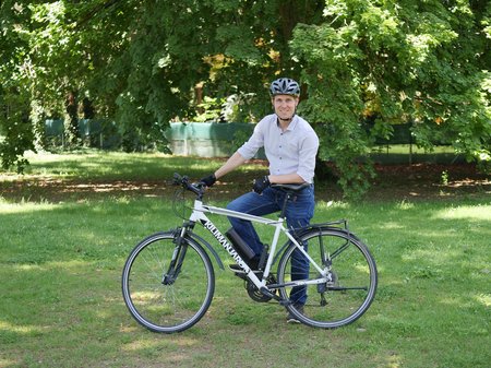 Herbert Hackl lehnt in Fahrradausrüstung an seinem Rad