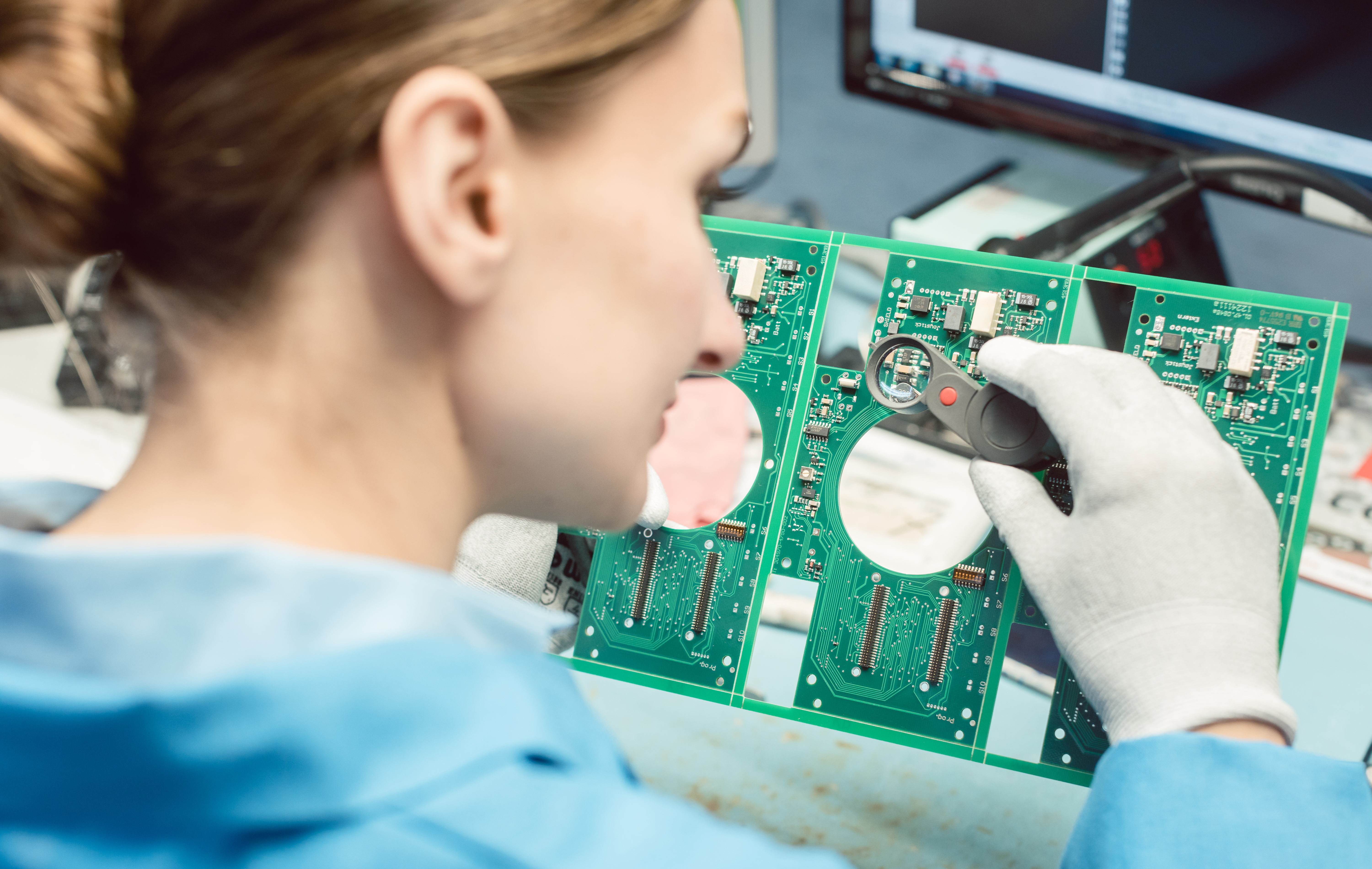 researcher soldering components to a printed circuit board